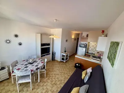 a kitchen and a living room with a dining room table at Appartement 2 pièces - 5 couchages Port la Nouvelle PN440-023 in Port-la-Nouvelle