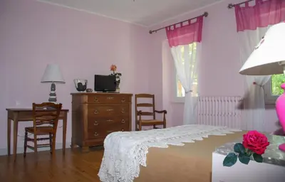 a bedroom with a bed and a desk and a dresser at L'Oustal d'en Paris in Nogaret