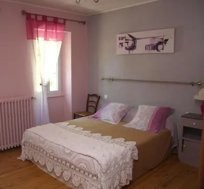 a bedroom with a large bed with a window at L'Oustal d'en Paris in Nogaret
