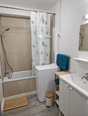 a white bathroom with a shower and a sink at Bord de mer avec piscine intérieure chauffée in Port-la-Nouvelle