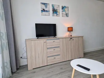 a tv on top of a dresser in a room at Bord de mer avec piscine intérieure chauffée in Port-la-Nouvelle