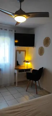 a room with a desk with a mirror and a chair at Bouddha Fleurs de Lotus in Sigean