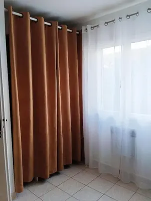 a room with brown curtains and a window at Bouddha Fleurs de Lotus in Sigean