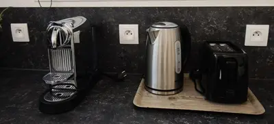 a coffeemaker sitting on a counter next to a cutting board at Bouddha Fleurs de Lotus in Sigean