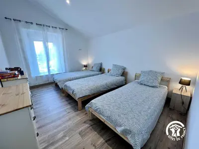 a bedroom with two beds and a window at Le gite aux oliviers in La Redorte