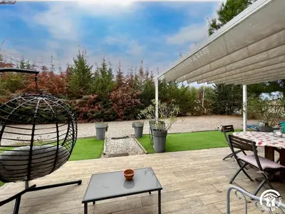 a patio with a table and chairs and a swing at Le gite du pech de saint jean in La Redorte