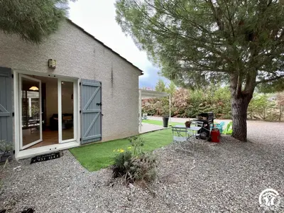 a backyard with a tree and a house at Le gite du pech de saint jean in La Redorte