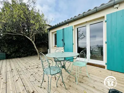 a patio with a table and chairs on a wooden deck at La maisonnette in Bages
