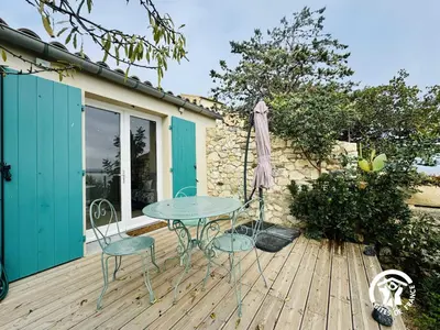 a patio with a table and chairs on a wooden deck at La maisonnette in Bages