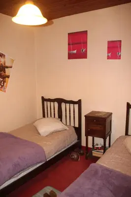 a bedroom with two beds and a night stand and a table at Chambre 2 in Saint-Michel-de-Lanès