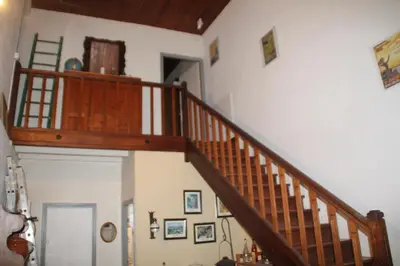 a wooden staircase in a room with pictures on the wall at Chambre 2 in Saint-Michel-de-Lanès