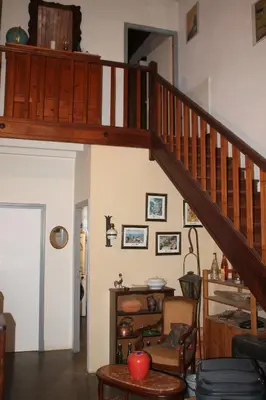 a living room with a wooden staircase in a house at Chambre 2 in Saint-Michel-de-Lanès