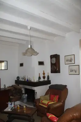 a living room with a couch and a fireplace at Chambre 2 in Saint-Michel-de-Lanès