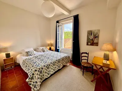 a bedroom with a bed and a window at Château de Gragnos in Saint-Chinian