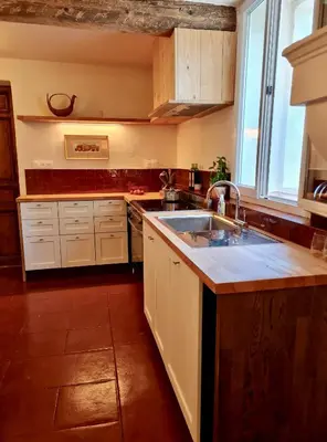 a kitchen with white cabinets and a sink at Château de Gragnos in Saint-Chinian