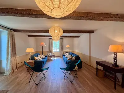 a living room with couches and chairs and a chandelier at Château de Gragnos in Saint-Chinian
