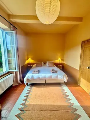 a bedroom with a bed and a large window at Château de Gragnos in Saint-Chinian