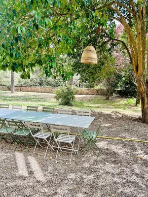 a picnic table and two chairs under a tree at Château de Gragnos in Saint-Chinian