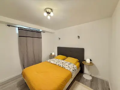 a bedroom with a bed with a yellow blanket at Logement en souplexe indépendant dans une propriété in Castres