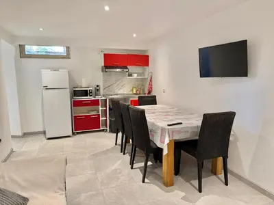 a kitchen with a table with chairs and a refrigerator at Logement en souplexe indépendant dans une propriété in Castres