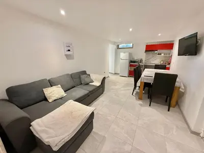 a living room with a couch and a table and a kitchen at Logement en souplexe indépendant dans une propriété in Castres