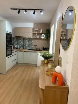 a kitchen with white cabinets and a mirror on a counter at L'étoile des remparts in Lagrasse