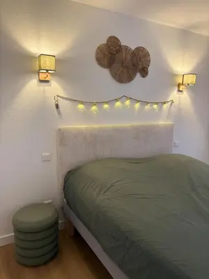 a bedroom with a bed with lights on the wall at L'étoile des remparts in Lagrasse