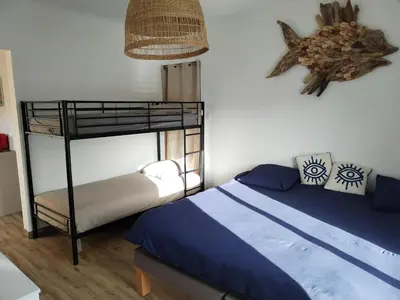 a bedroom with a bunk bed with blue sheets at Le Repaire Secret, studio cosy et calme Narbonne in Narbonne