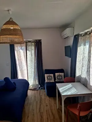 a living room with a blue couch and a table at Le Repaire Secret, studio cosy et calme Narbonne in Narbonne