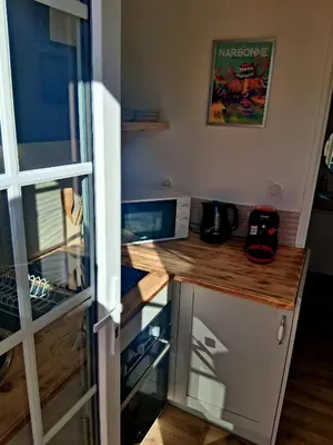 a kitchen with a counter with a computer on it at Le Repaire Secret, studio cosy et calme Narbonne in Narbonne