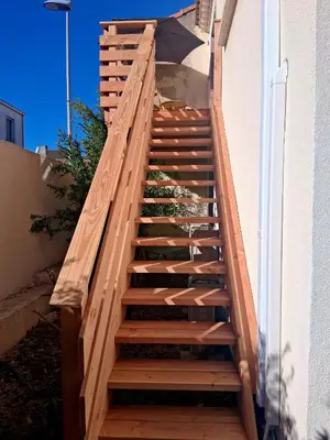 a wooden staircase leading up to a building at Le Repaire Secret, studio cosy et calme Narbonne in Narbonne