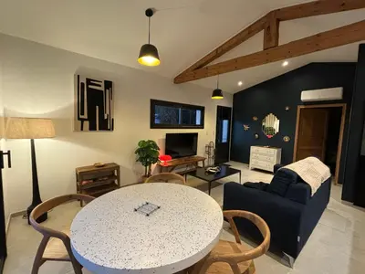 a living room with a table and a couch at Le jardin de la Vade in Carcassonne