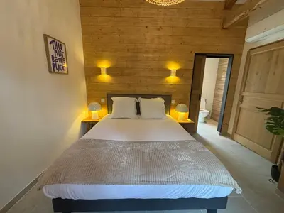 a bedroom with a large bed with two lamps on it at Le jardin de la Vade in Carcassonne
