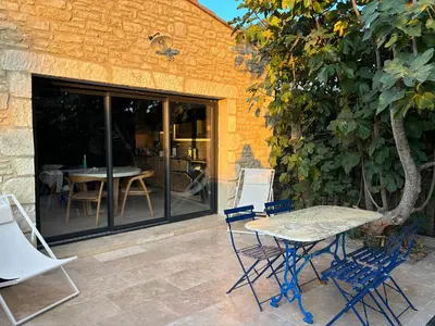 a patio with a table and chairs next to a building at Le jardin de la Vade in Carcassonne