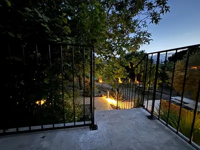 an open gate to a driveway with lights on it at Le jardin de la Vade in Carcassonne