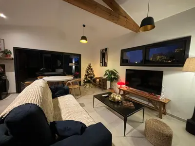 a living room with a couch and a tv at Le jardin de la Vade in Carcassonne