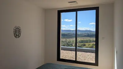a bedroom with a window with a view of the mountains at Oxyzenvilla 11200 Saint-André-de-Roquelongue in Saint-André-de-Roquelongue