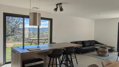 a kitchen and living room with a table and chairs at Oxyzenvilla 11200 Saint-André-de-Roquelongue in Saint-André-de-Roquelongue
