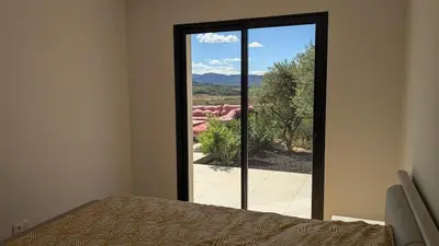 a room with a bed and a window with a view at Oxyzenvilla 11200 Saint-André-de-Roquelongue in Saint-André-de-Roquelongue