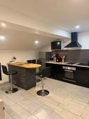 a kitchen with a table and chairs in it at Cosy Room Trèbes in Trèbes