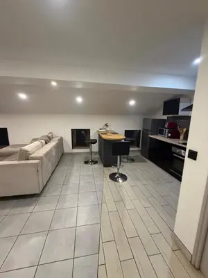 a large living room with a couch and a kitchen at Cosy Room Trèbes in Trèbes
