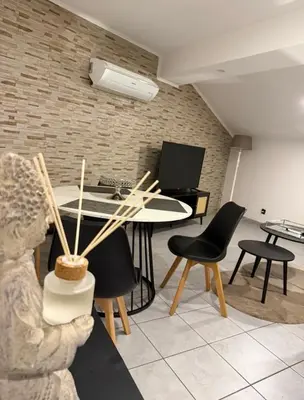 a room with a table and chairs and a statue at Cosy Room Trèbes in Trèbes