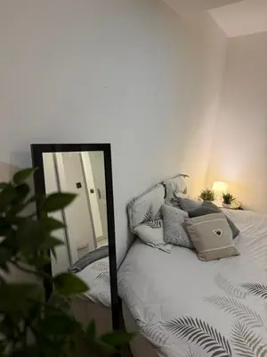 a mirror sitting next to a bed in a bedroom at Cosy Room Trèbes in Trèbes