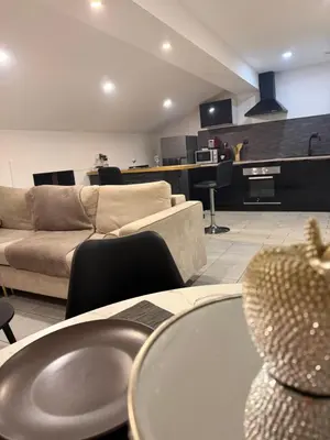 a living room with couches and tables and a kitchen at Cosy Room Trèbes in Trèbes