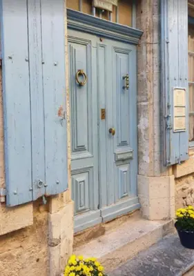 a blue door on the side of a building with flowers at La Maison Bleue de Sigean - CHX4 in Sigean