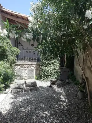 an old stone building with a door and windows at La maison de la fontaine in Villeneuve-Minervois
