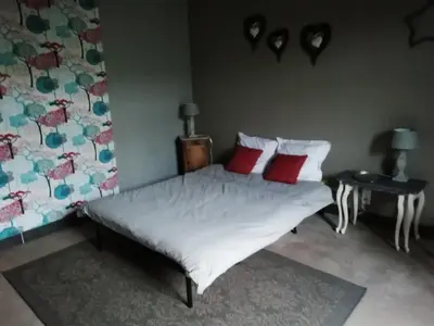 a bedroom with a bed and a table and chairs at La maison de la fontaine in Villeneuve-Minervois