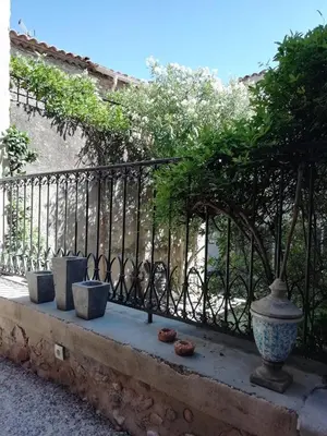 a blue table with plates and wine glasses on it at La maison de la fontaine in Villeneuve-Minervois