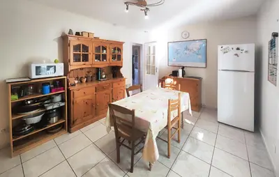 a kitchen with a table and a white refrigerator at Pet Friendly Home In Saint Chinian With Wifi in Saint-Chinian