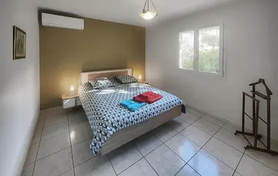 a bedroom with a bed with a comforter and a window at Pet Friendly Home In Saint Chinian With Wifi in Saint-Chinian